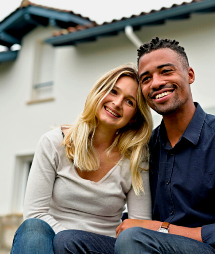 Interracial happy couple in front of home