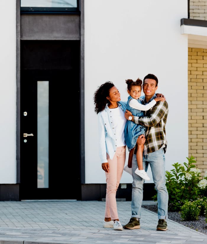 Interracial Family standing outside of their modern home